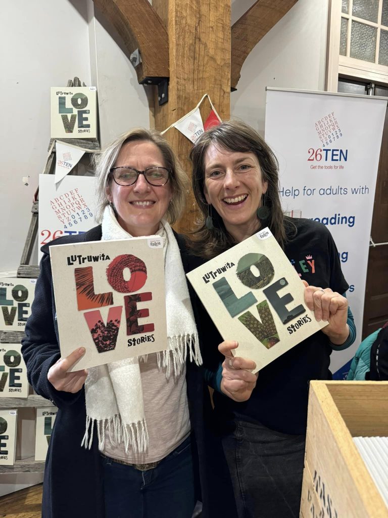 Two 26Ten Coordinators, Kate & Lucy, holding two volumes of Lutruwita Love Stories